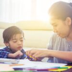 A very young school student learning from his tutor